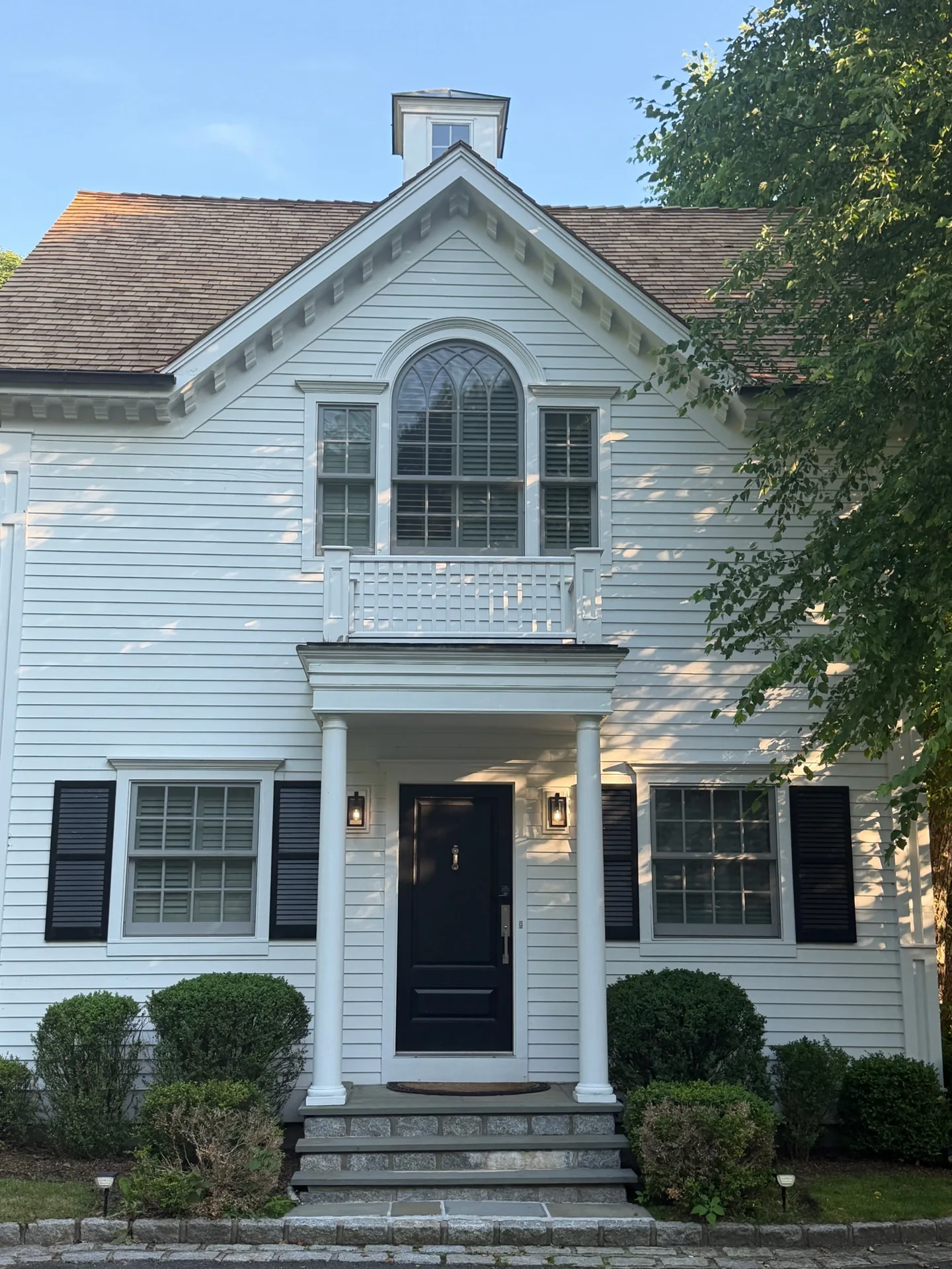 Roof Replacement in Washington, CT — White colonial and carriage house — matching cedar roofs, cupola flashing, and copper-lined gutter details.